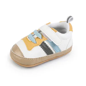 Dettaglio laterale di sneaker per neonati in pelle bianca con accenti gialli e blu e velcro