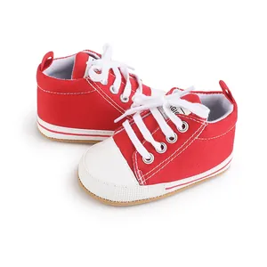 Primer plano de zapatillas de lona rojas y blancas para bebés con cordones blancos