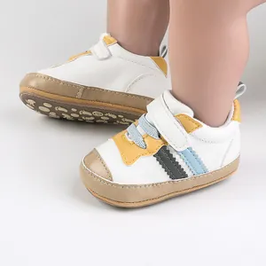 Dettaglio ravvicinato di scarpe da camminata in pelle bianca per neonati colorate