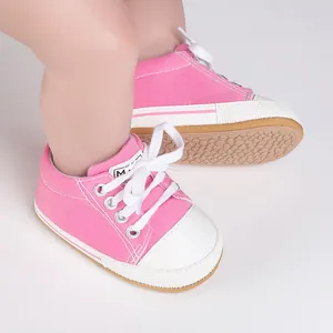 Detalle de zapatillas de lona rosa para bebé con suela suave para primeros pasos