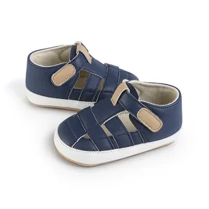 Detailed view of navy blue baby pre-walker shoes with white soles and tan straps
