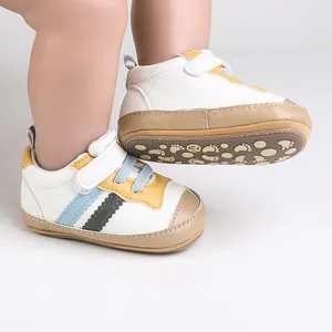 Vista dettagliata delle scarpe primi passi per neonati con strisce bianche e gialle.