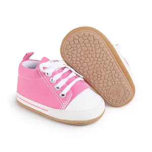 Vista detallada de los zapatos de lona rosa para bebés con suela de goma antideslizante