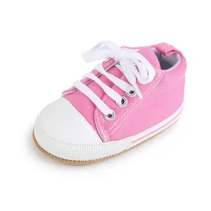 Vista detallada de zapatos de lona rosa para bebé primeros pasos con cordones