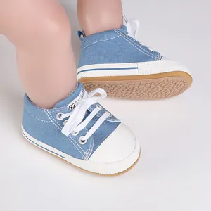 Detalle de zapatos de lona vaquera azul para bebé con suelas suaves antideslizantes.