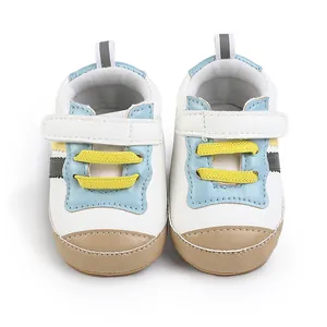 Dettaglio vista frontale di scarpe bianche primi passi per neonati con lacci gialli
