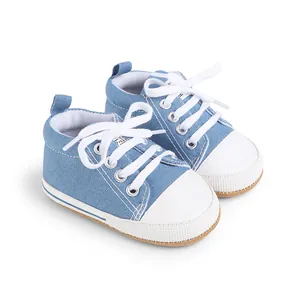 Detalle de zapatos de lona azul para bebé con cordones blancos y puntera protectora