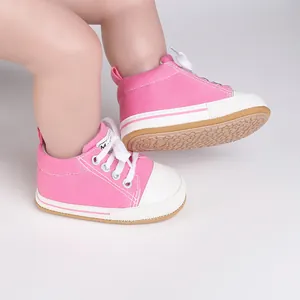 Detailed view of pink baby walker shoes with non-slip soles and white canvas toes