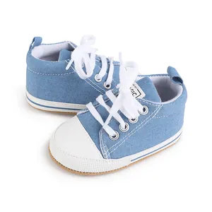 Vista detallada de zapatillas de lona azules para bebé con cordones blancos y puntera de goma.