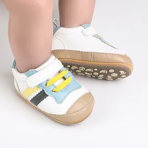 Dettaglio di scarpe primi passi per neonati in morbida pelle bianca con suola antiscivolo