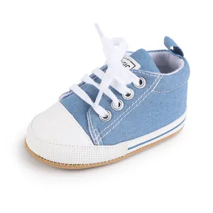 Primer plano de zapatilla de lona vaquera azul para bebé con cordones y puntera blanca