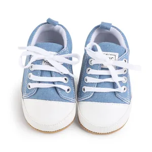Vista detallada de zapatos de lona azul para bebés con cordones blancos y puntera