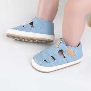 Close-up view of light blue leather baby walker shoes with adjustable strap on baby's feet.