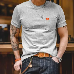Camiseta gris ajustada de cuello redondo para hombre con bolsillo y etiqueta naranja de la marca
