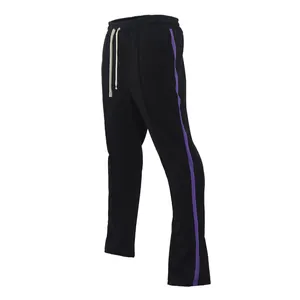 Detailed view of black men's flare sports pants with purple side stripes and drawstrings.