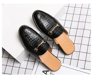Vue détaillée des mules en cuir pour hommes avec boucle mors dorée et gaufrage