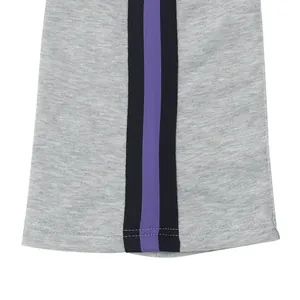 Close-up detail of grey flared sports pants with black and purple side stripes