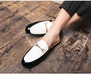 Gros plan de mules en cuir pour hommes avec tige blanche et boucle en métal doré