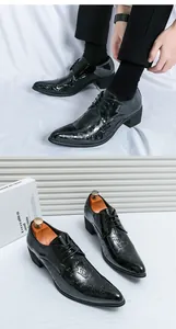 Close-up detail of black patent leather men's dress shoes with paisley pattern and block heel