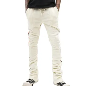 Close-up detail of men's slim fit stacked joggers with side stripes and off-white textured fabric