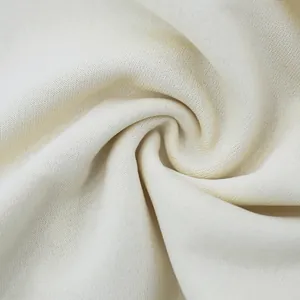 Macro shot of premium cream-white knit fabric showing soft texture and fine weave.