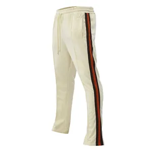 Side view of men's cream flared sports pants with orange and black side stripes.