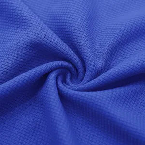 Macro view showing the detailed waffle knit texture of blue men's summer clothing fabric