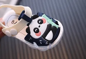 Close-up detail of infant summer sandal featuring a cute cartoon panda ornament with bamboo