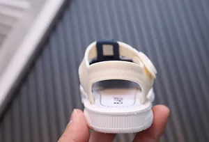 Detailed view of the heel and flexible soft sole on a white baby summer sandal