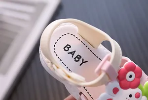 Close-up detail of baby girl summer sandal with cute cartoon rabbit and flower decor