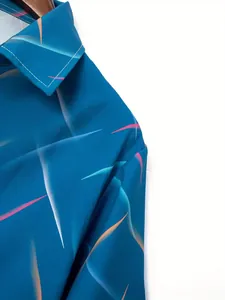 Detail macro shot showing vibrant feather pattern on men's blue beach short sleeve shirt.