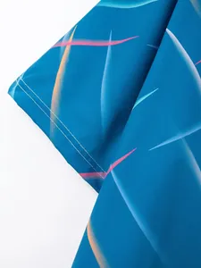 Close-up of men's blue beach shirt with colorful feather pattern and neat stitching
