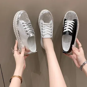 Detailed view of stylish women's platform sneakers with rhinestone toes in silver white and black