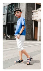 Sandalias deportivas azules para niños usadas por un modelo en una calle urbana de verano