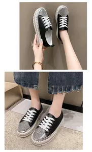 Detailed view of women's black sneakers with rhinestone toe and thick platform sole.