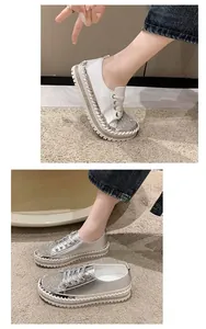 Detail view of stylish rhinestone platform sneakers with thick soles in silver and white.