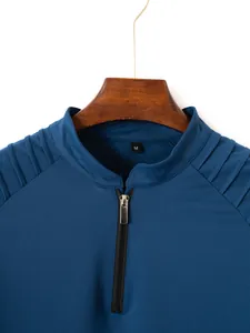 Close-up of men's blue sports zipper shirt with shoulder patchwork detail