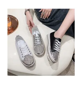 Close-up of stylish women's rhinestone platform sneakers in white, silver and black