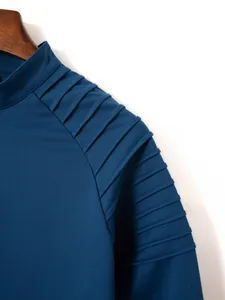 Close-up detail of a blue men's sports zip-up jacket featuring pleated shoulder design.