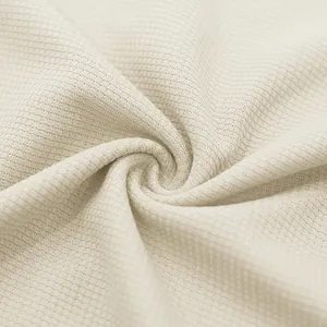 Macro close-up of the breathable beige waffle knit fabric texture for men's casual summer set.