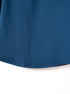 Detailed close-up showing the curved hem and precise stitching of a blue sports zip-up shirt