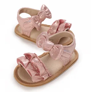 Detailed close-up of pink glittery baby sandals with ruffles and cute bow decoration