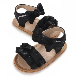 Detailed view of black baby sandals with cute ruffles and bow, anti-slip soft sole.