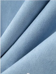 Macro detail of soft light blue suede fabric showing fine texture and quality
