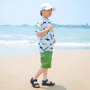 Young boy wearing lightweight blue sporty sandals on a sunny sandy beach during summer.