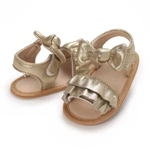 Detail view of gold baby pre-walker sandals featuring ruffle accents and a stylish bow design.