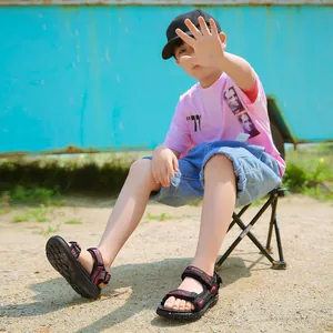 Outdoor lifestyle detail of boys' lightweight beach sandals with soft sole and velcro