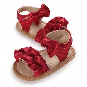 Detailed macro view of red glittery baby sandals featuring ruffle and bow design accents