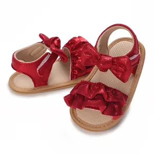 Detailed macro view of red sparkly baby sandals with ruffles and cute bow decoration.