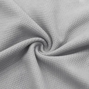Detail macro view of soft grey waffle knit fabric texture for minimalist men's summer set.